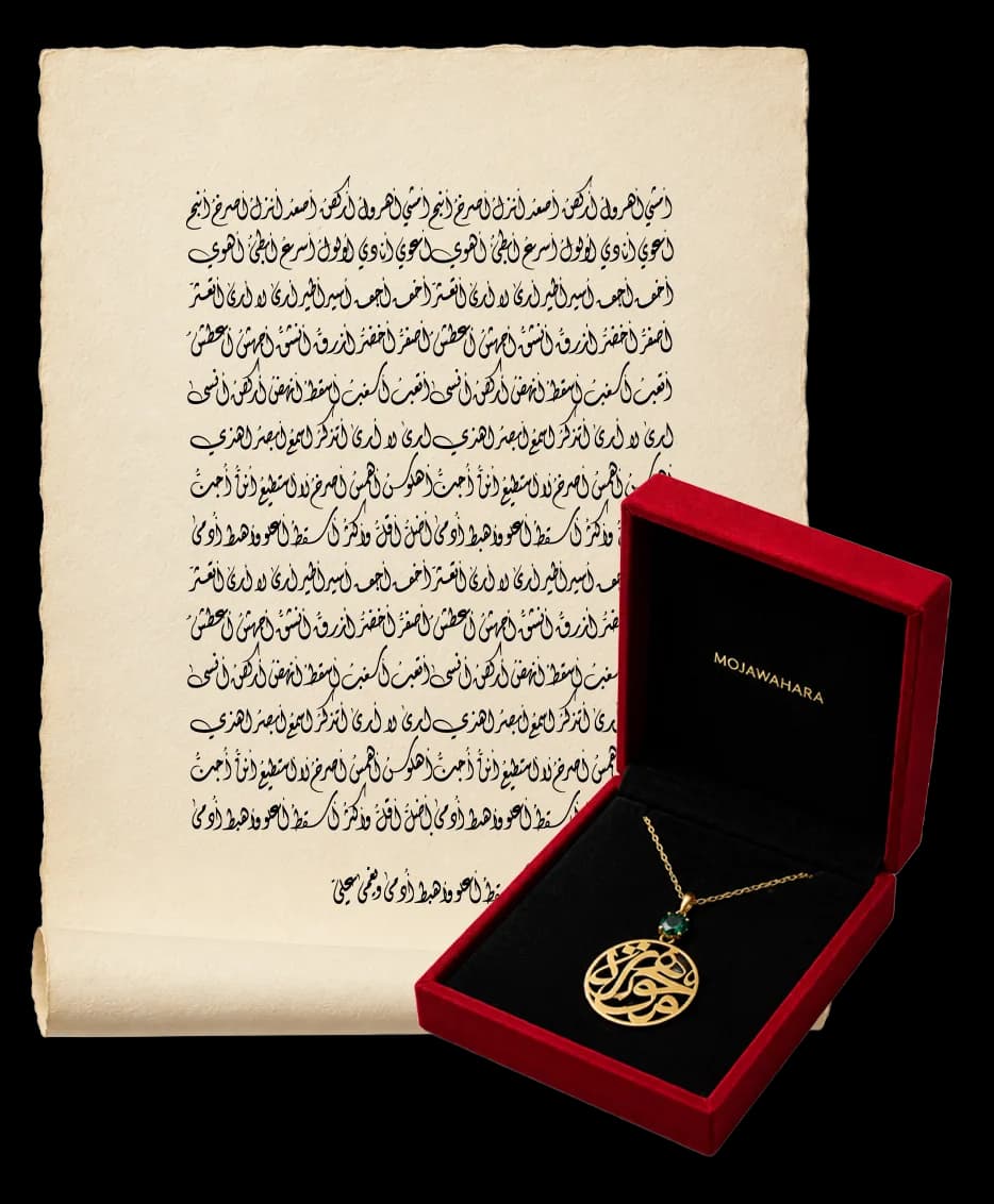 A private letter handwritten in Arabic calligraphy on natural paper, beside a Mojawhara pendant in gold and a green gemstone, resting in its red presentation case.