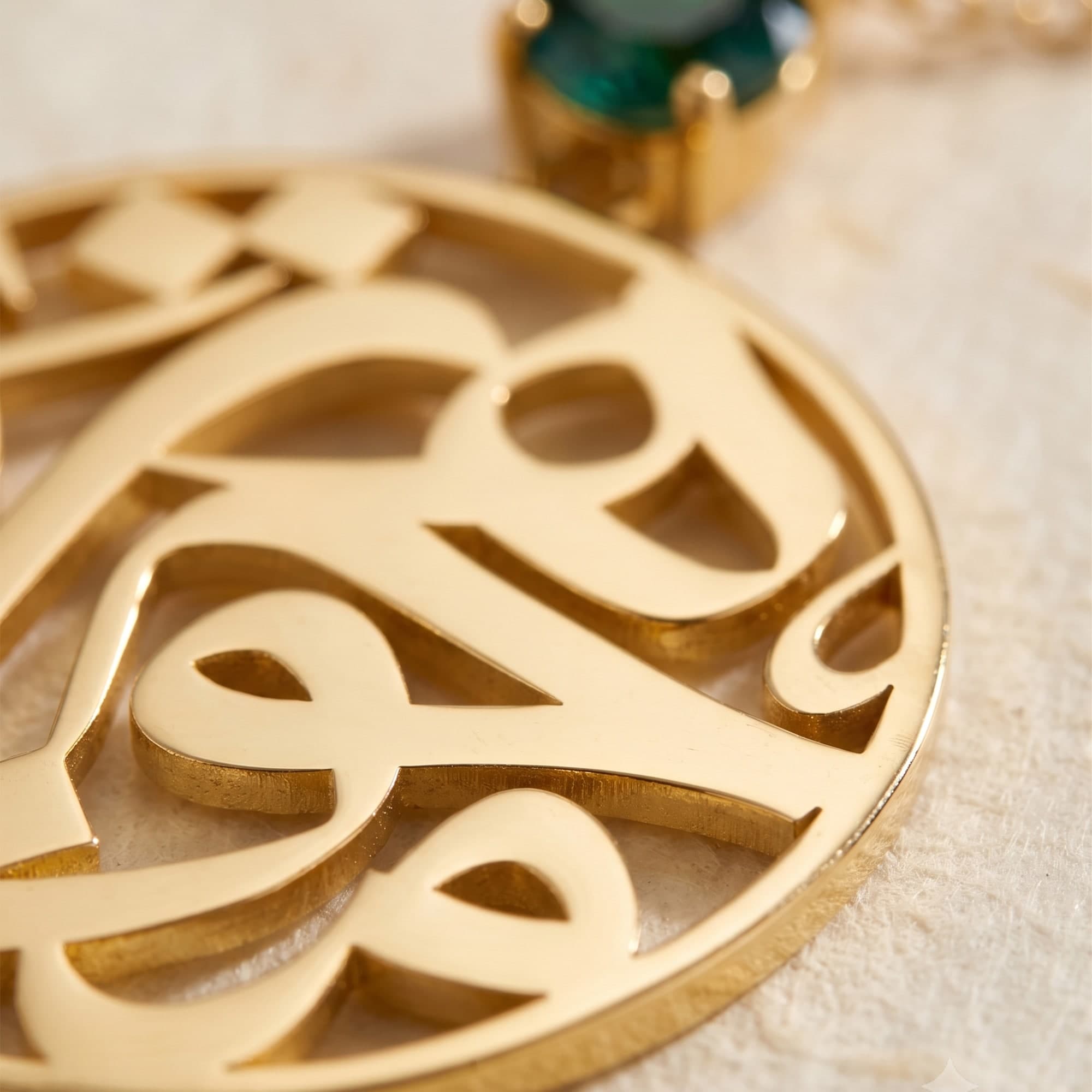 Drawn in a continuous circle of Arabic Thuluth calligraphy, Mojawhara carries the meaning of its name, “the jewel.” Sculpted in 18K gold and illuminated by a green sapphire, the necklace brings heritage and contemporary form into quiet balance. Worn close to the heart, it becomes both an emblem of t