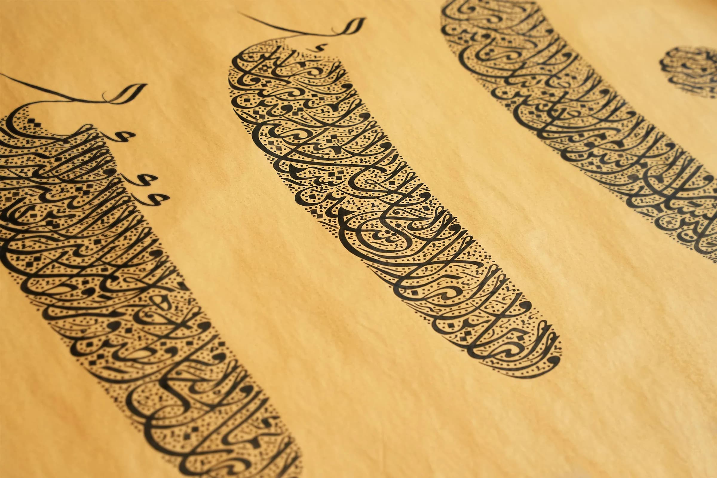 Panels of authored Arabic calligraphy drawn in black ink on warm paper, the letterforms massed into dense vertical compositions.